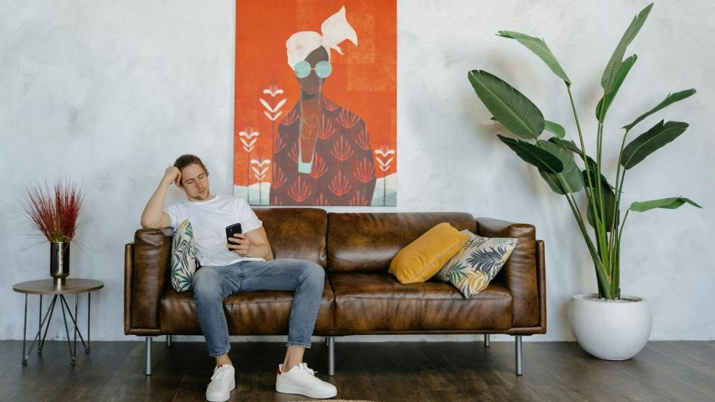 A man sitting on a couch looking at his phone.