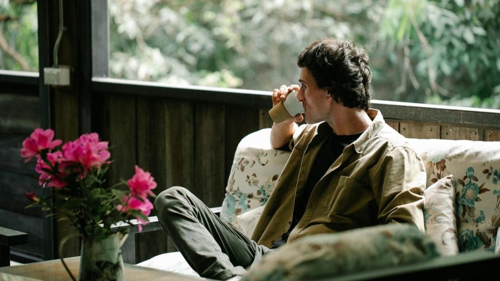 A man sitting and drinking from a cup.