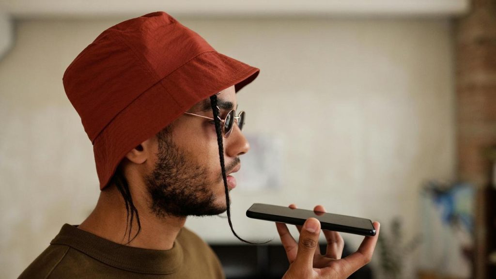 A man wearing a hat speaking into a phone.