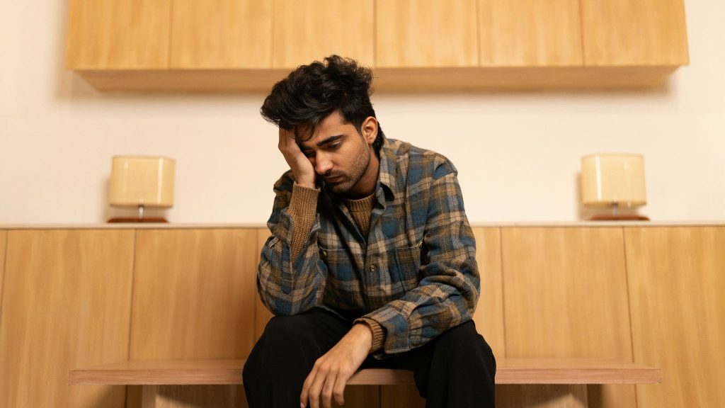 A man sitting and looks like with low energy