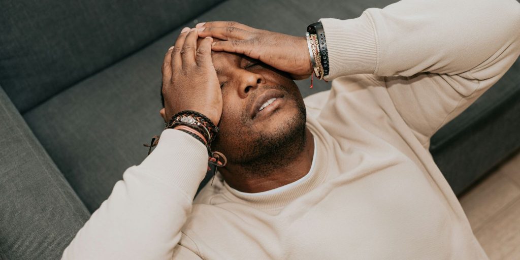 A man lying his head on the sofa