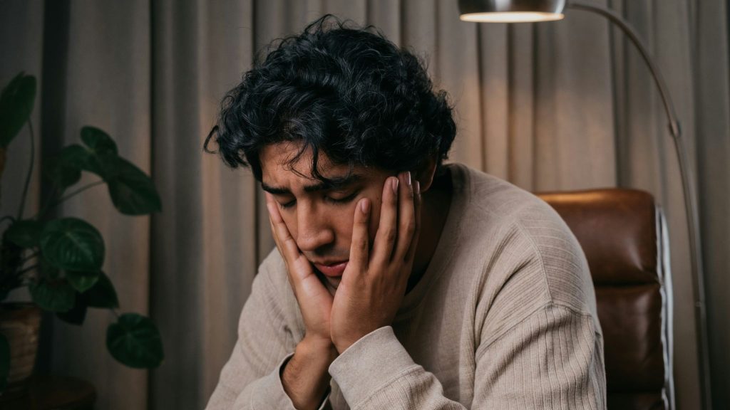 Sad man holding his face