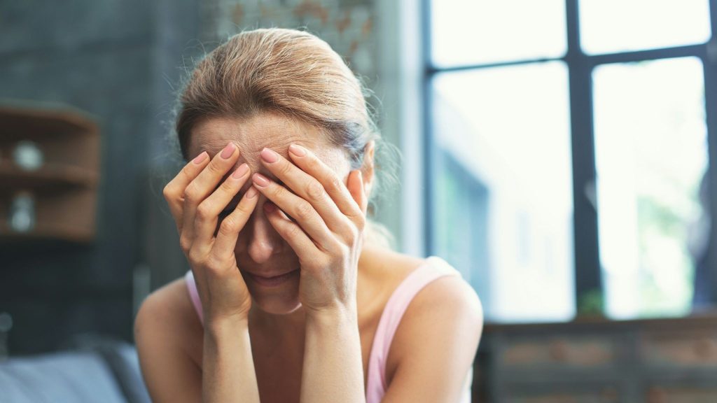 Sad woman sitting and covering her face