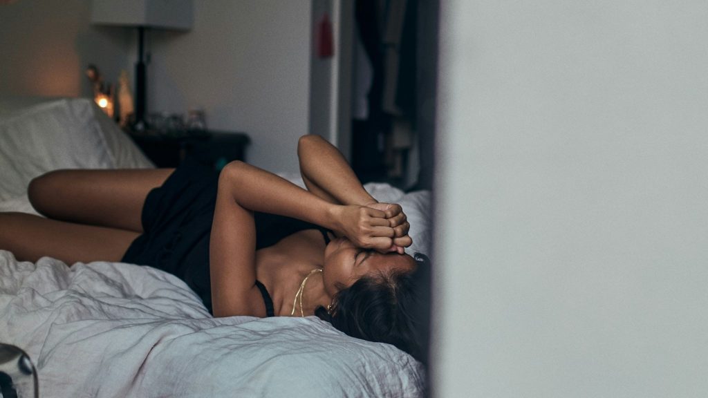 Woman crying while lying on the bed