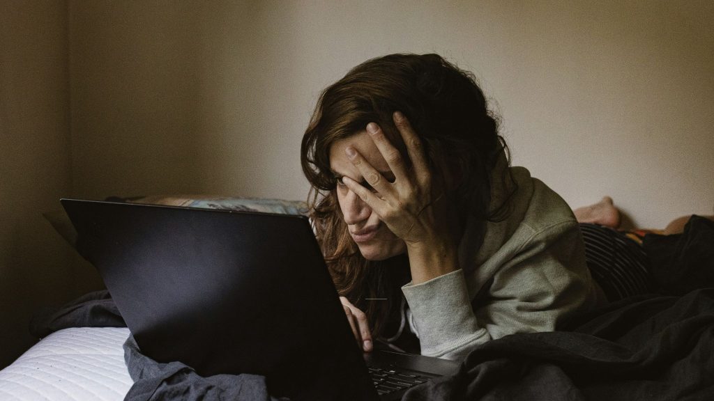 Woman looking bored while looking at the laptop