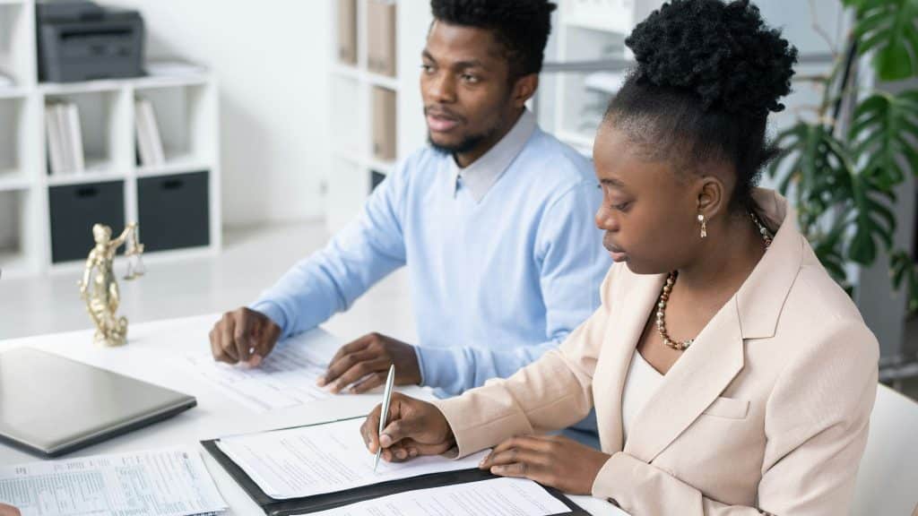 A man and woman signing paper