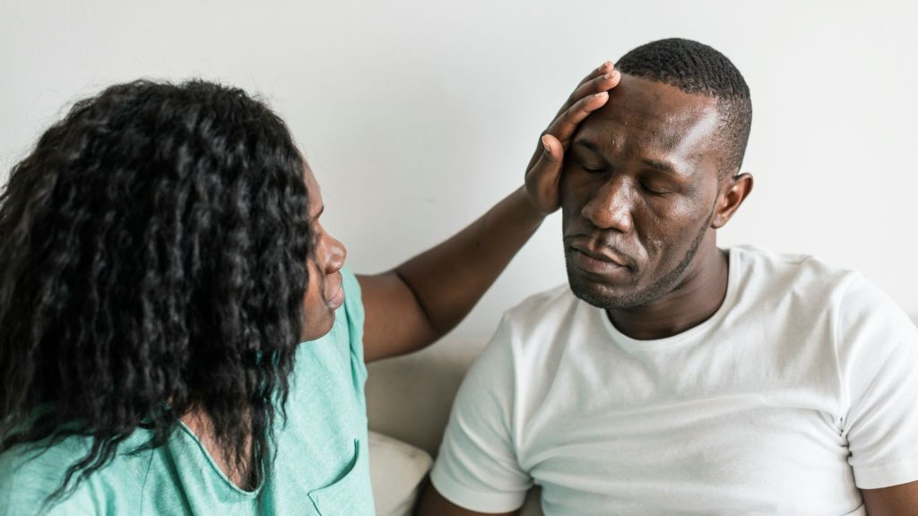 A woman holding man’s head