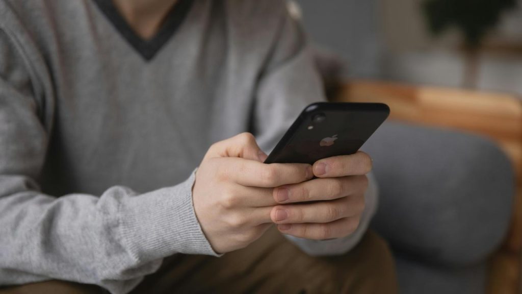A person holding and using a smartphone.