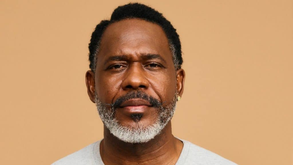 A mature bearded man looking at the camera with a serious expression.