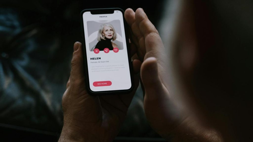 A person viewing a woman’s profile on a dating app.