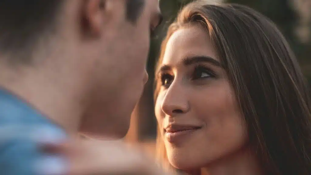 A happy woman with her head tilted, looking up at a man.